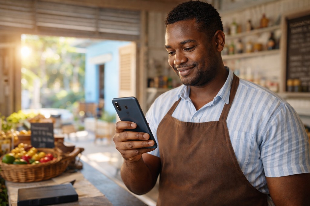 Business owner in his shop, checking his phone — get paid and run your day
